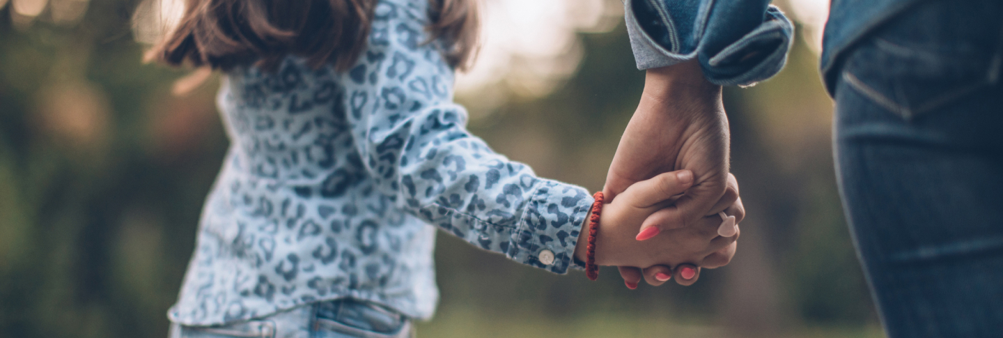 Gros plan sur une mère et sa fille qui se tiennent par la main