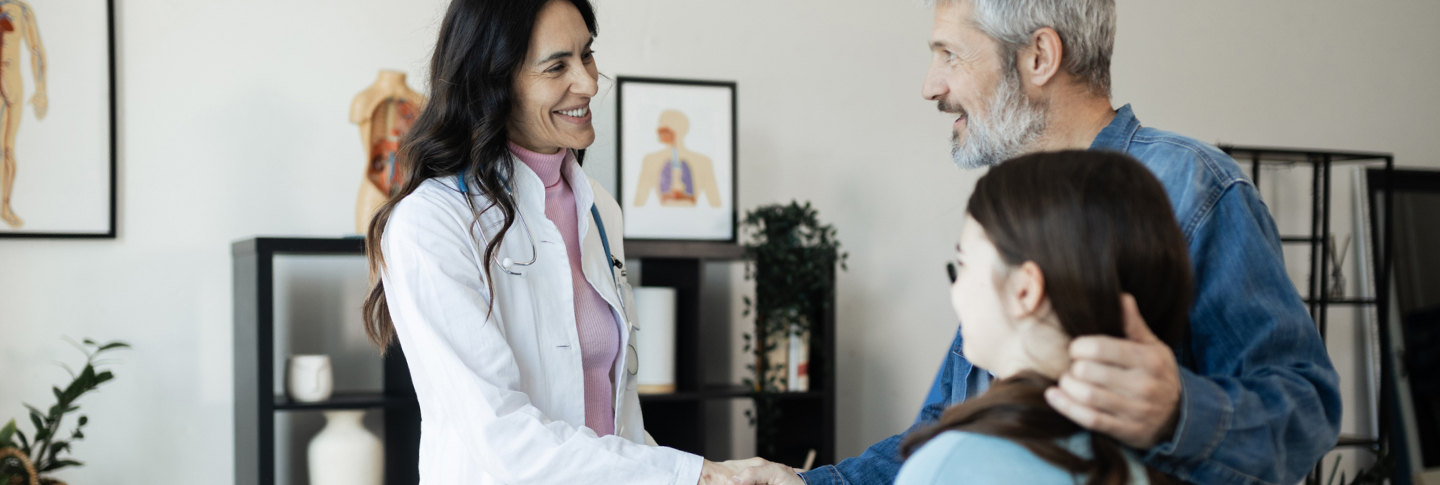 Une médecin discute avec un père et sa fille